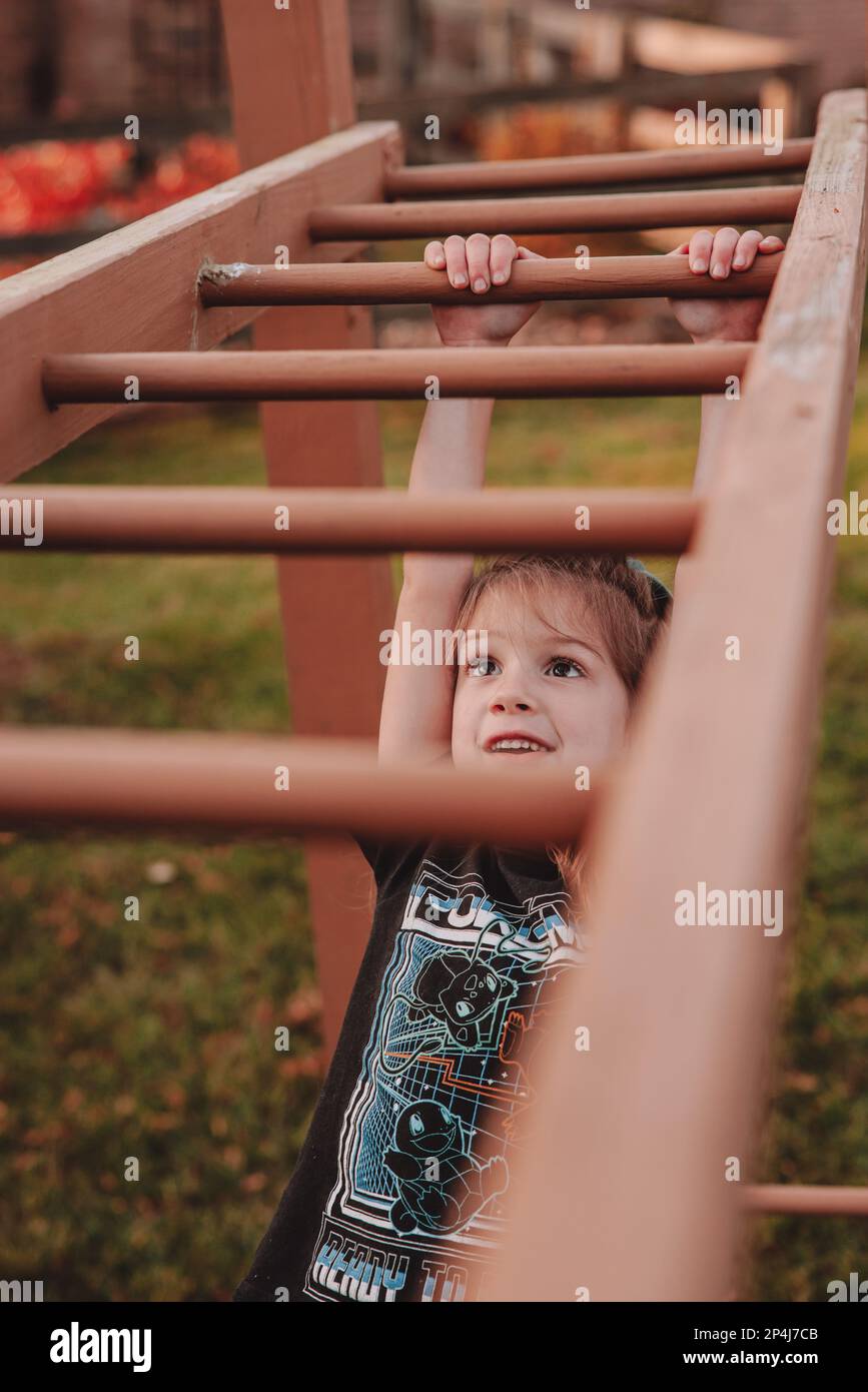 Learning how to go across the monkey bars Stock Photo Alamy
