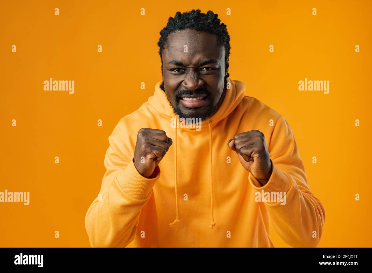 Portrait of excited african guy celebrating success with clenched fists