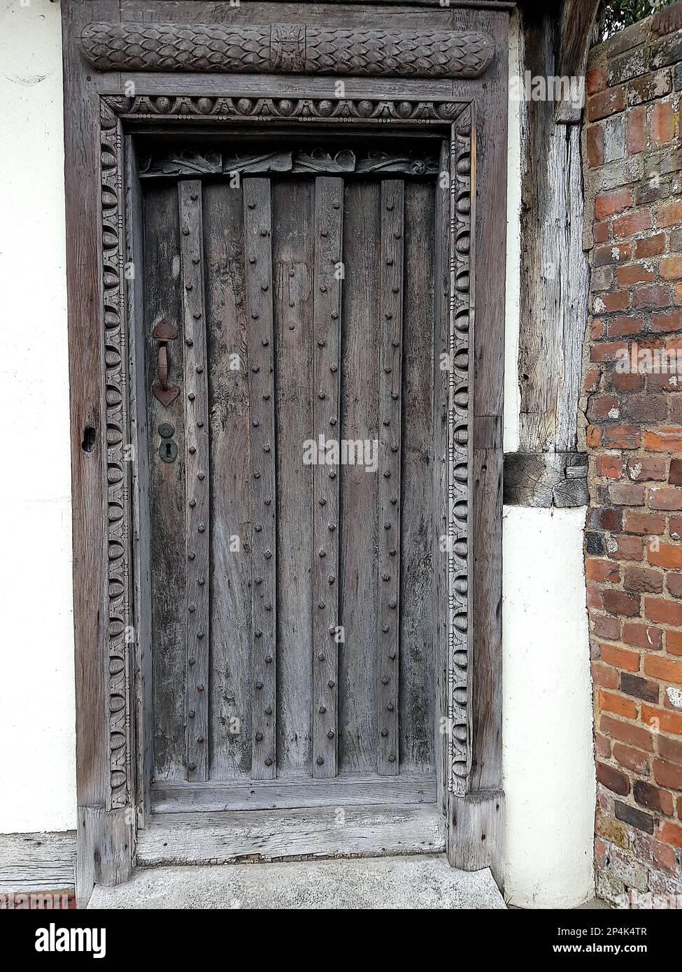 A traditional studded decorative wood panelled door. Stock Photo