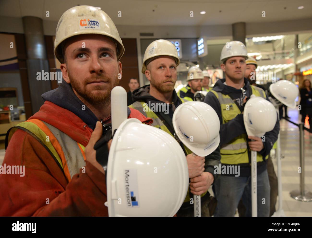 Construction workers look on during the groundbreaking ceremony for