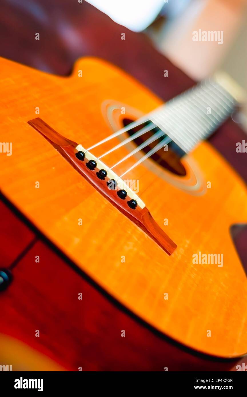 A close up of classical acoustic guitar with nylon strings, lying on a couch. Stock Photo