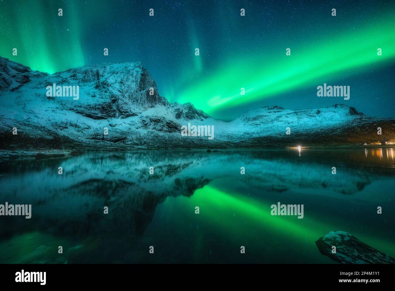 Northern lights over snowy mountains, sea, reflection in water Stock ...