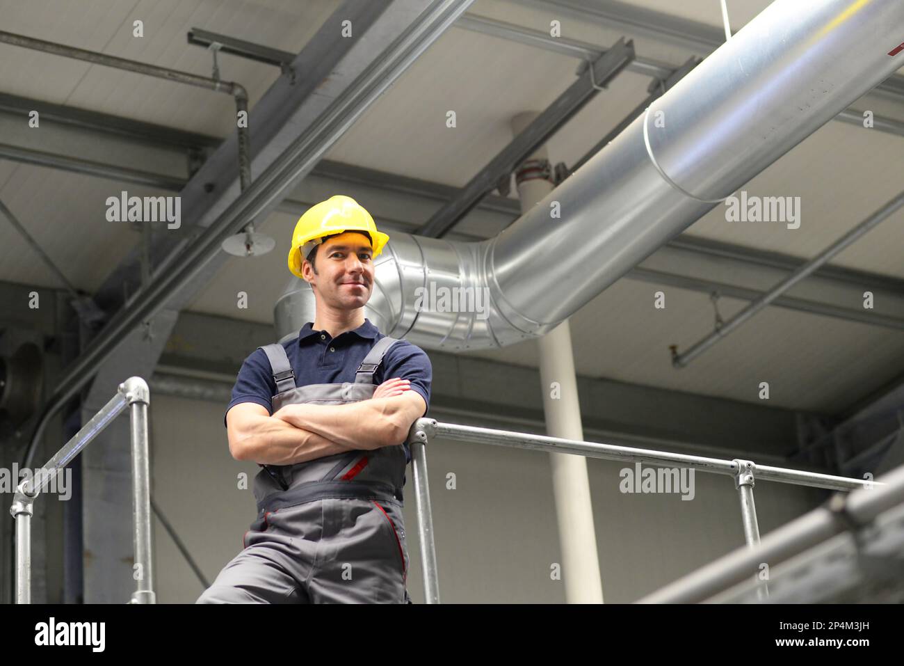 portrait of successful workman in an industrial company, in working clothes at the workplace  - closeup Stock Photo