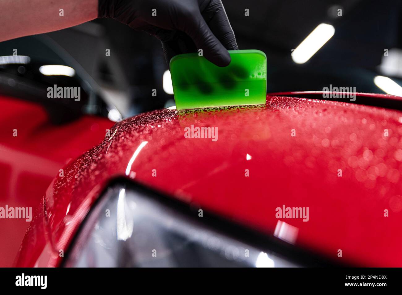 Application of a colorless protective film at a car detailing studio or