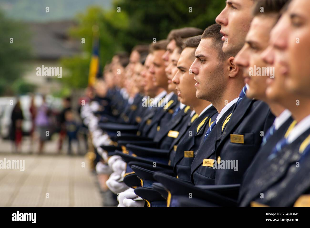 A group of soldiers wearing matching uniforms and hats stand in a neat