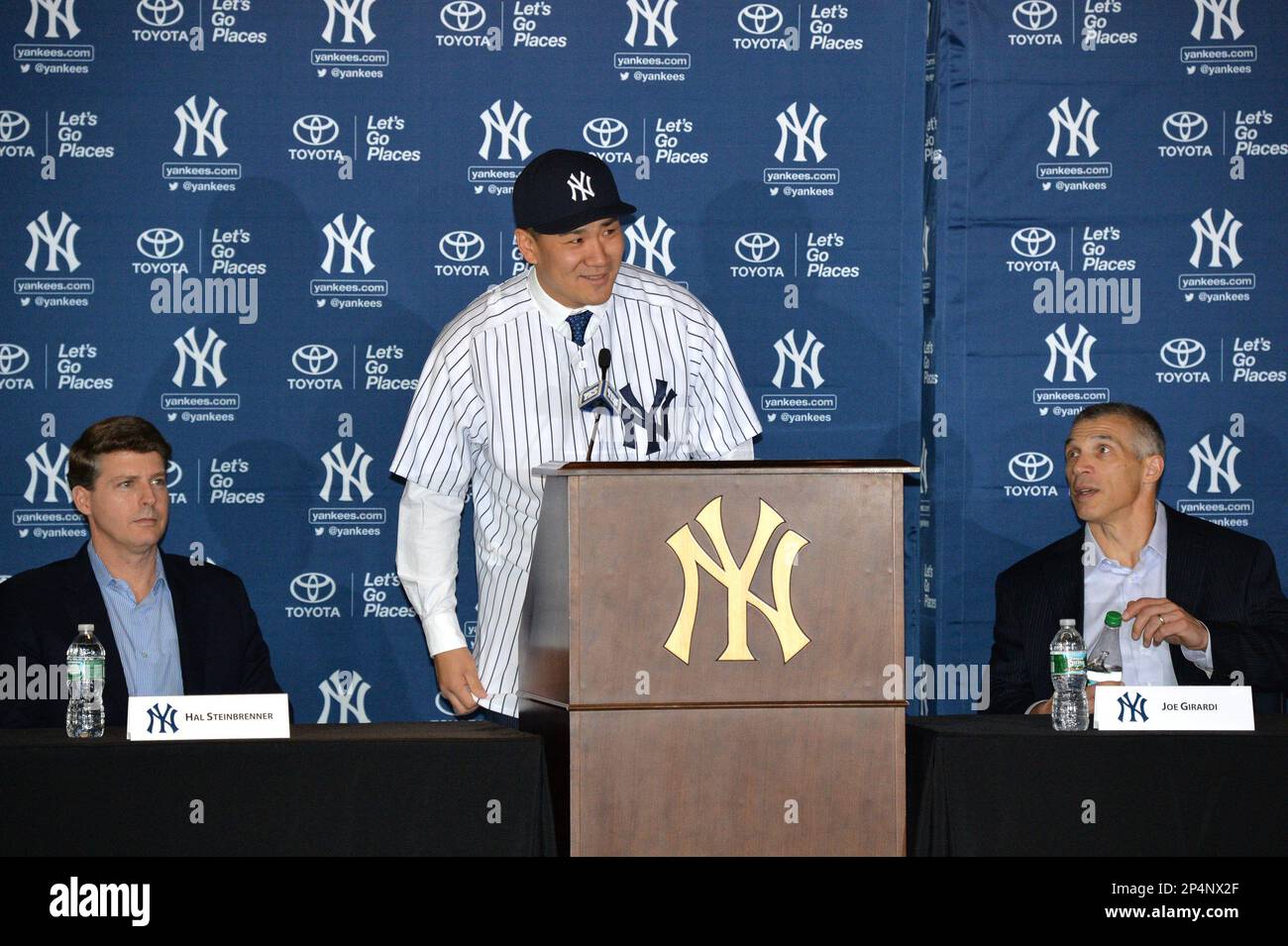 New York Yankees Manager Joe Girardi shakes hands with Masahiro Tanaka who  is wearing his new Yankees jersey and cap at a press conference at Yankee  Stadium in New York City on