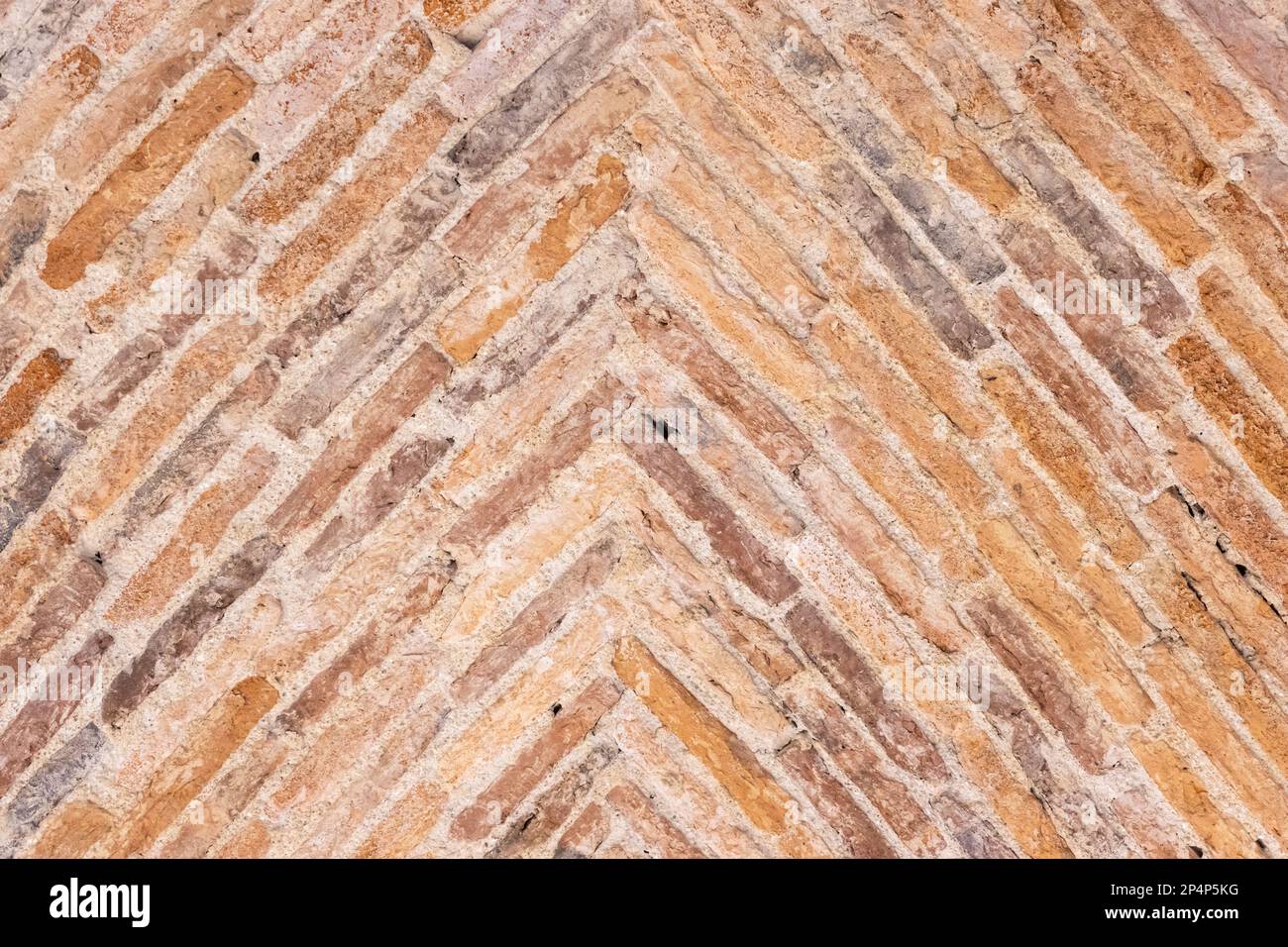 Background of old bricks laid in a herringbone pattern on a vault of a 17th century building. Full frame Stock Photo