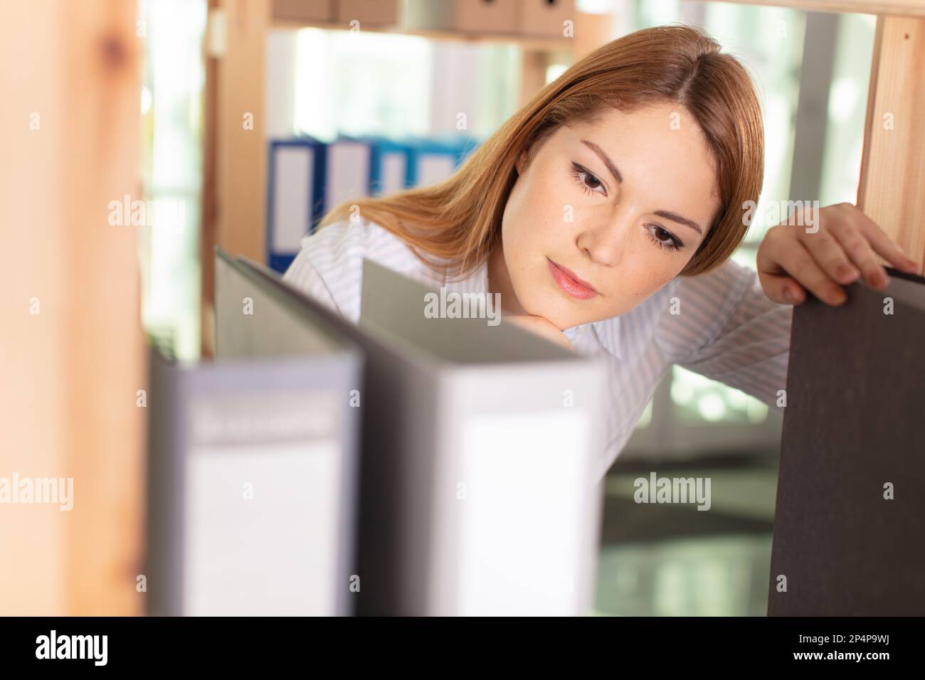 young happy businesswoman searching file in office Stock Photo