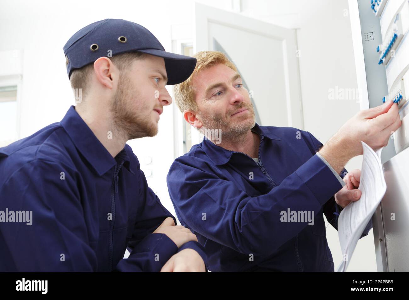 two technicians read a plan in the workshop Stock Photo