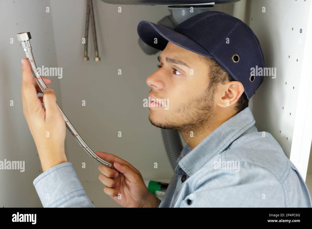 man fixing pipes under the sink Stock Photo Alamy
