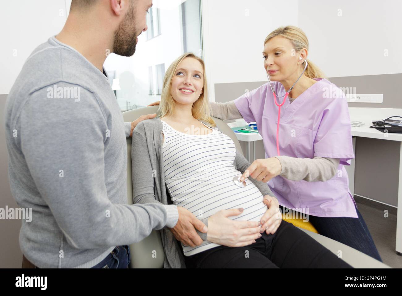 female doctor consulting with a young pregnant couple Stock Photo - Alamy