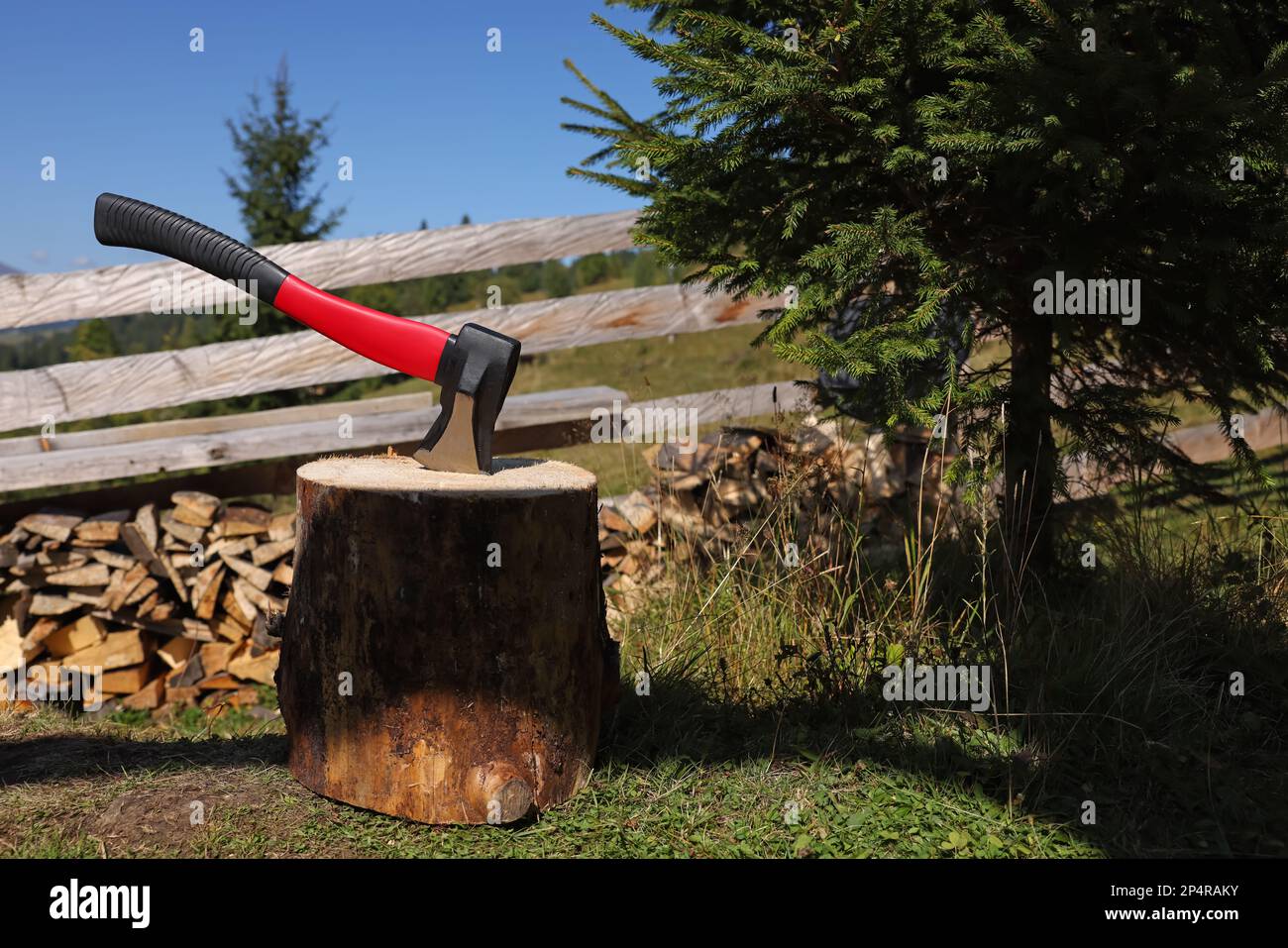 Tree stump with axe and cut firewood outdoors, space for text Stock ...