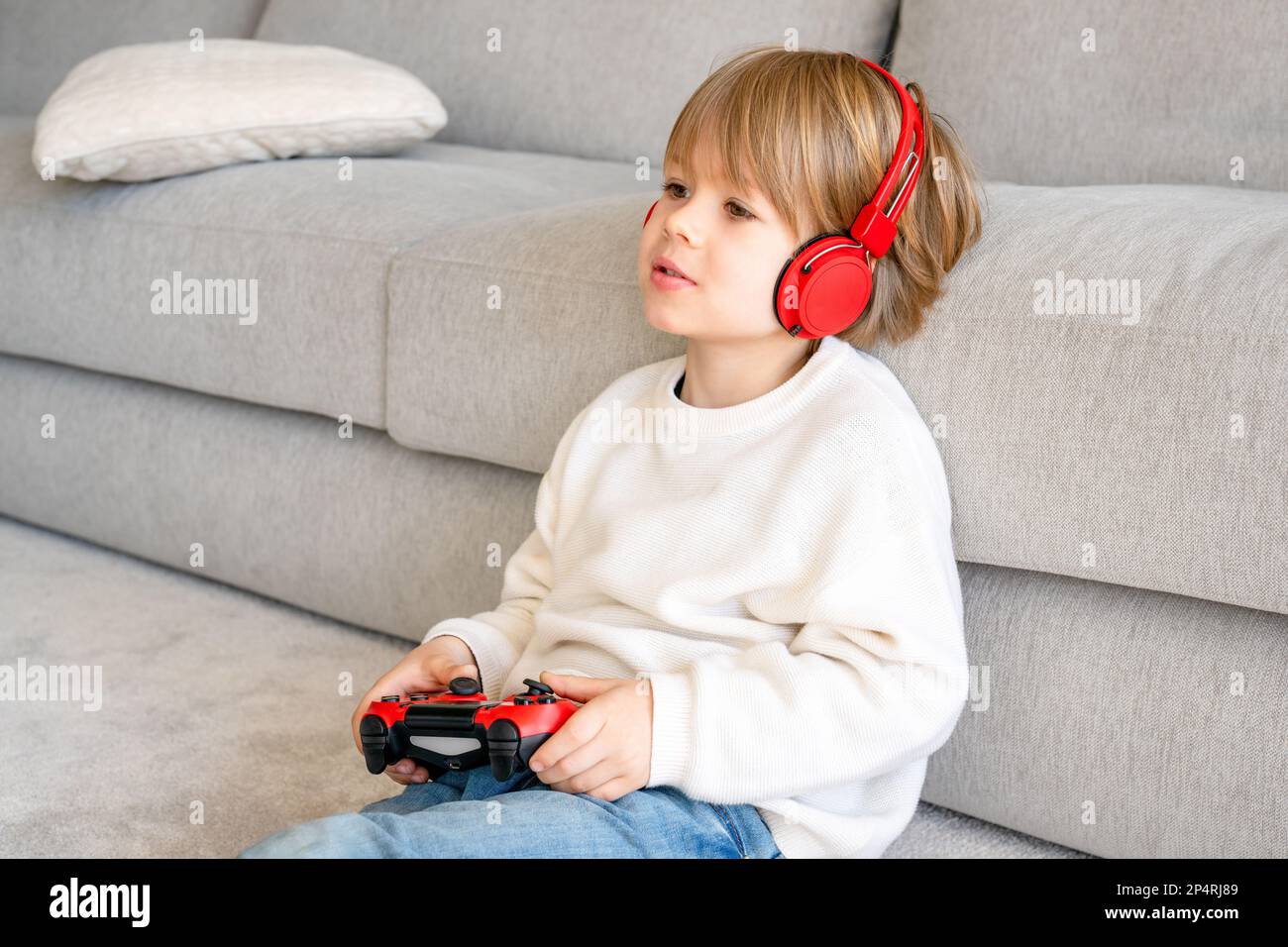 Two brothers playing football video game console, sitting on yellow pouf in  kids play center Stock Photo - Alamy