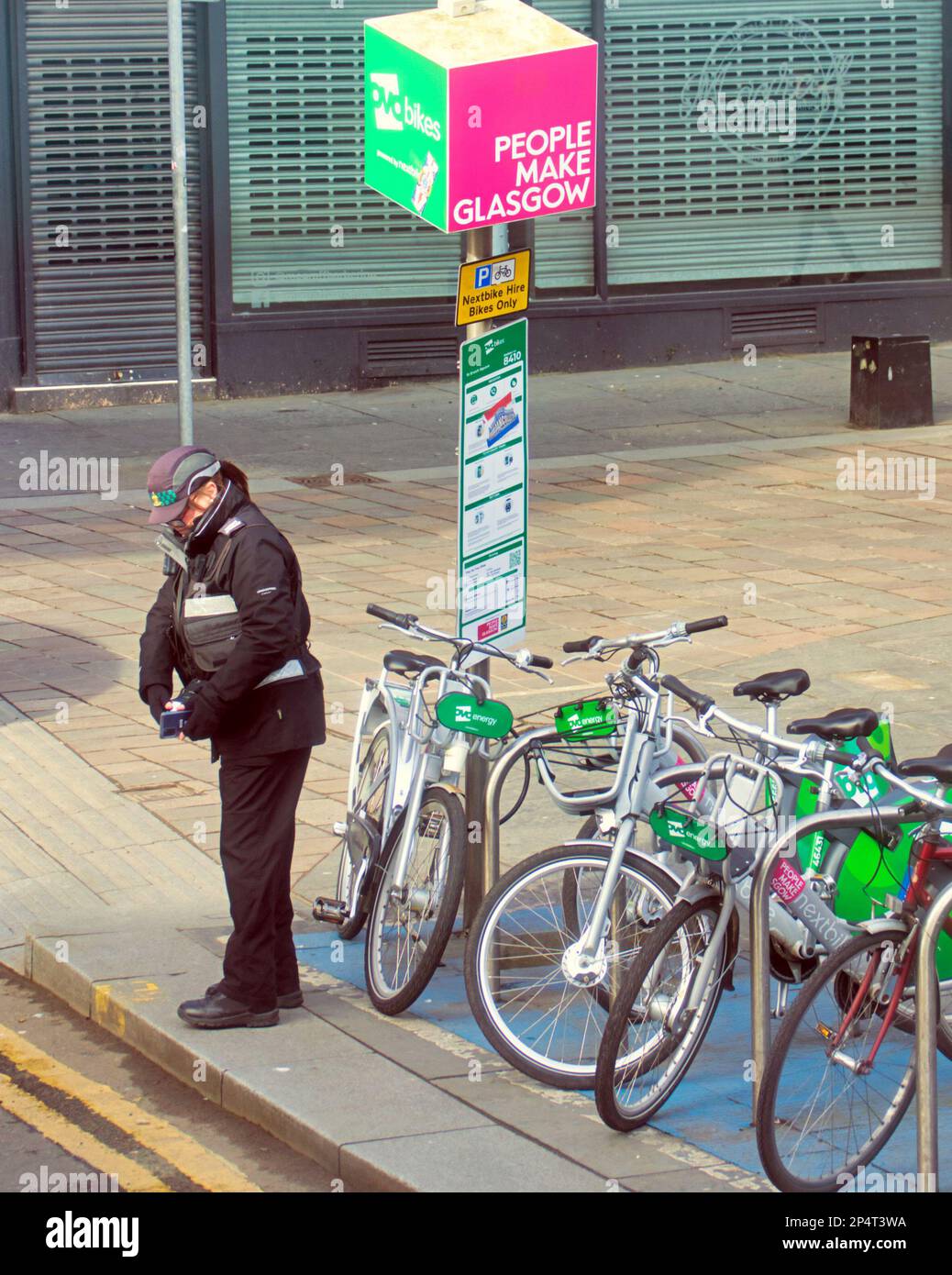 Glasgow, Scotland, UK 6th March, 2023. UK Weather:  Sunny start saw happier locals as the streets filled in the spring weather before the forecast return of winter. Parking warden wonders if she can ticket e bikes.st enoch square. Credit Gerard Ferry/Alamy Live News Stock Photo