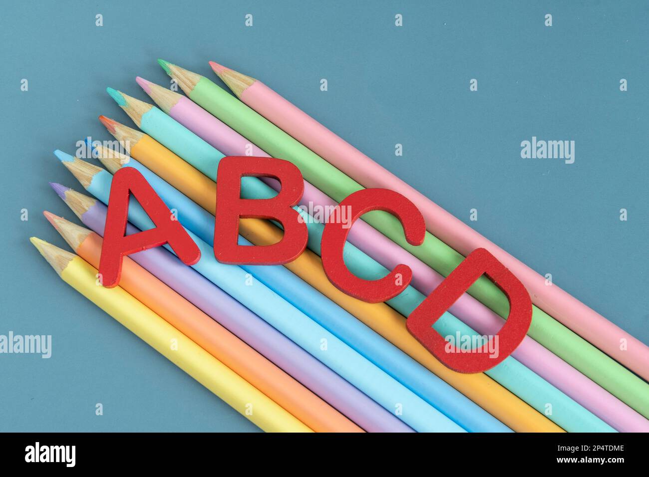 Back to school concept with assorted letters and colored pencils in ...