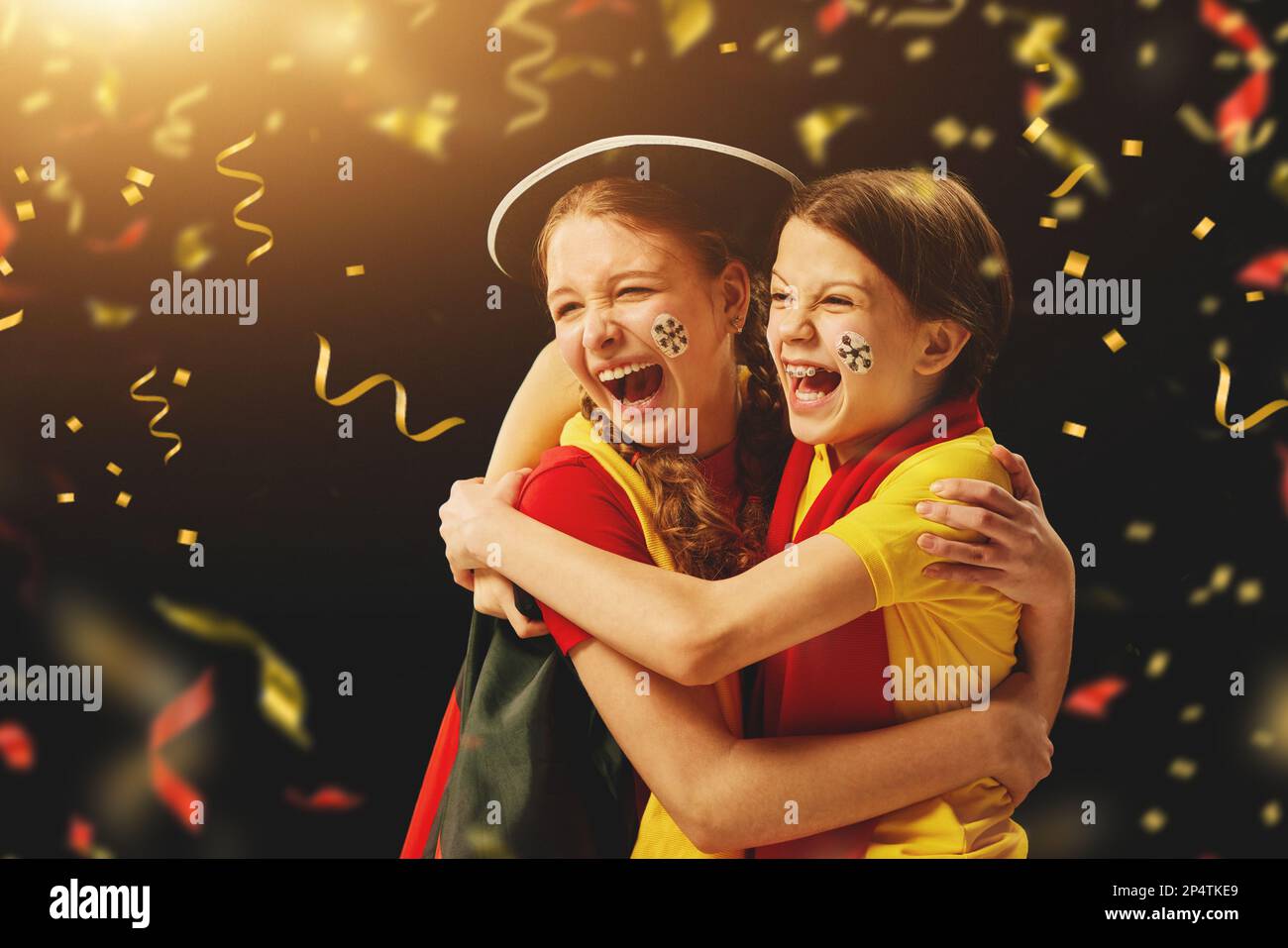 Hugging in happiness. Teen girls emotionally watching match, cheering ...