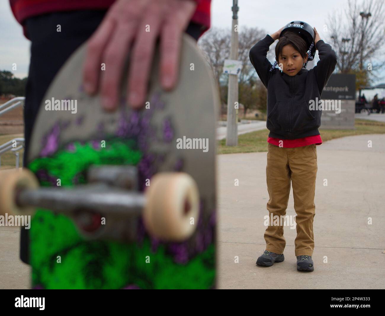 skateboarder Richard Tarco, 8, puts on his helmet that he received from