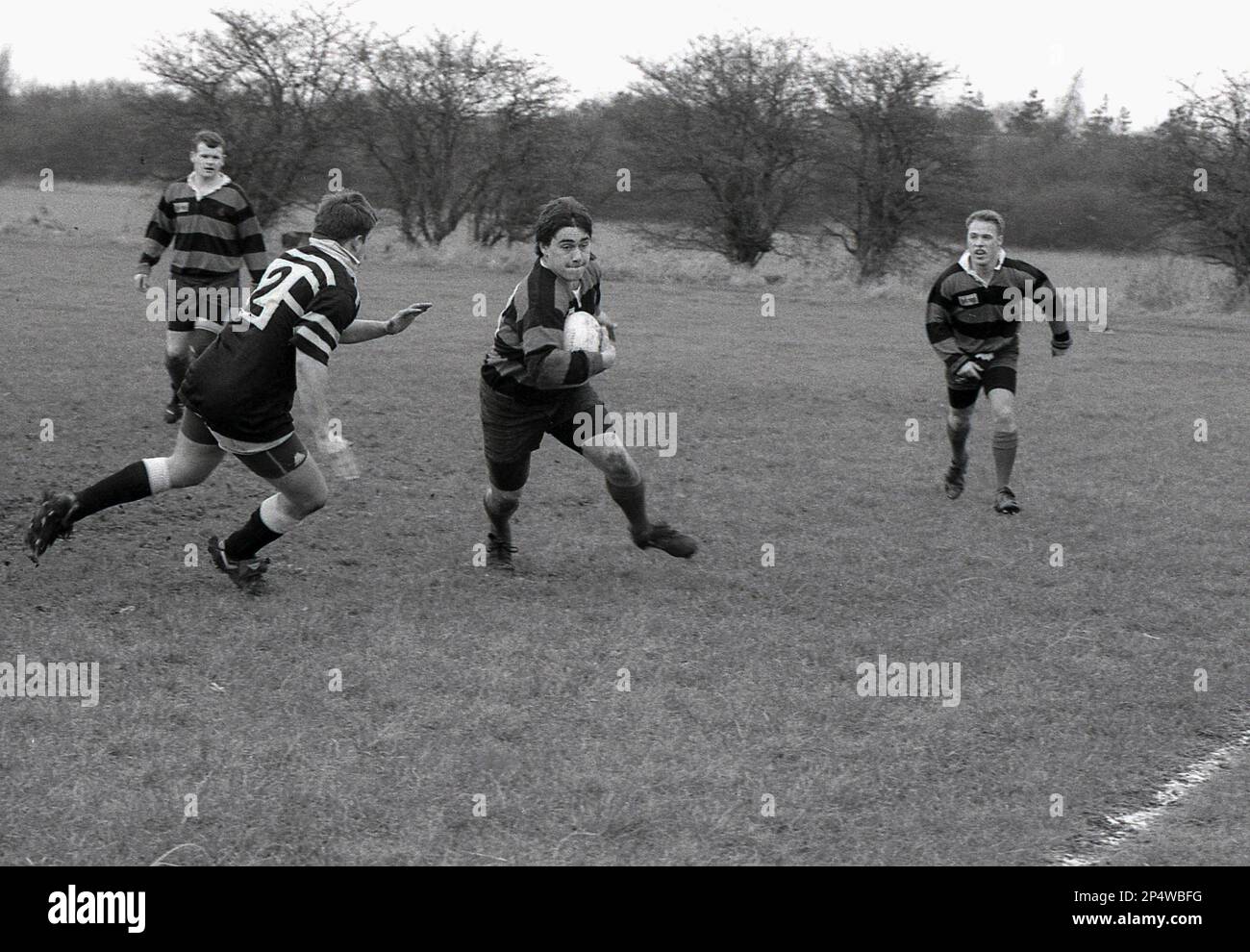 1980s, amateur rugby match, a scrumhalf with ball in hand, moving to ...