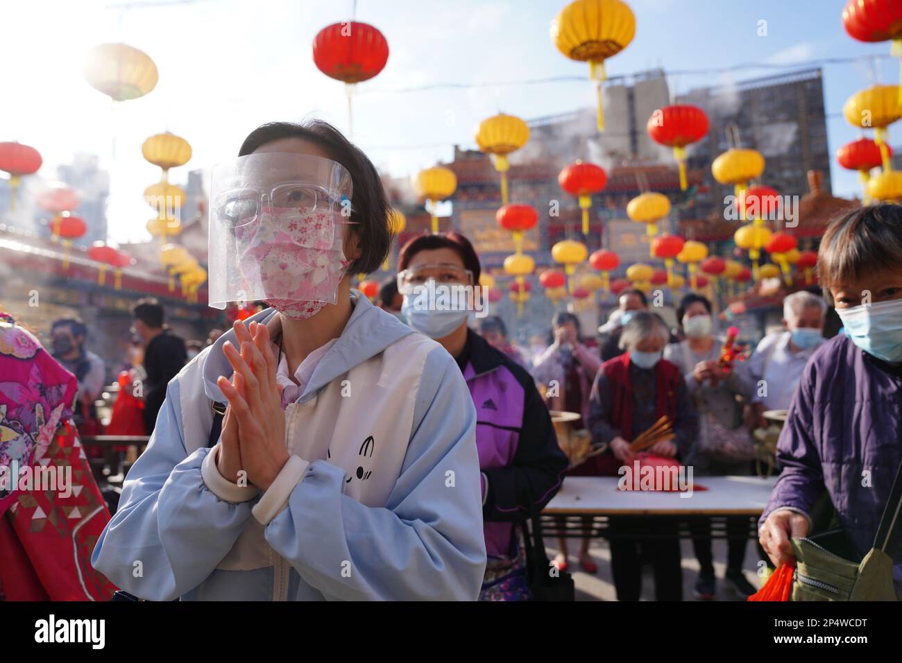 Worshippers make offering on the first day of the Chinese Lunar New Year at the Wong Tai Sin Temple, amid the Covid-19 crowd-control measures.  12FEB21   SCMP / Sam Tsang Stock Photo
