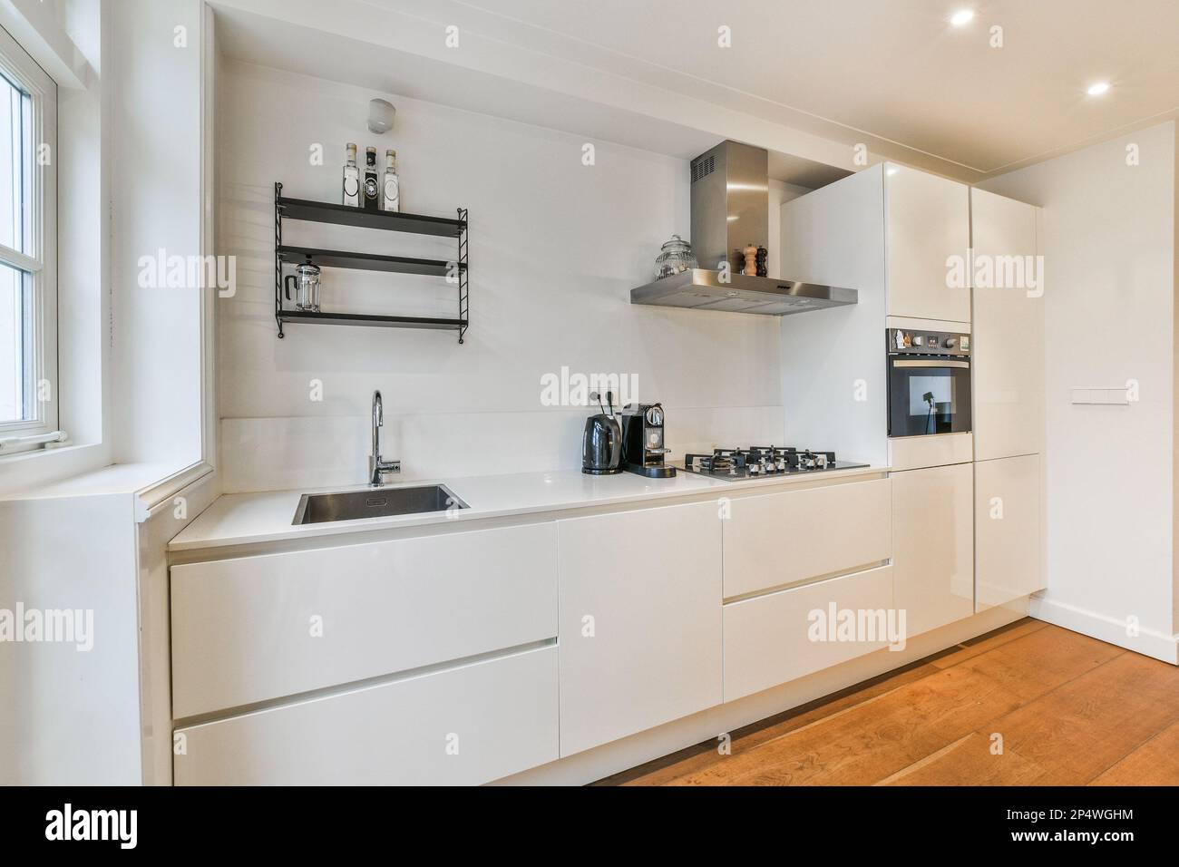 a kitchen with wood flooring and white cabinets in the corner, there is ...