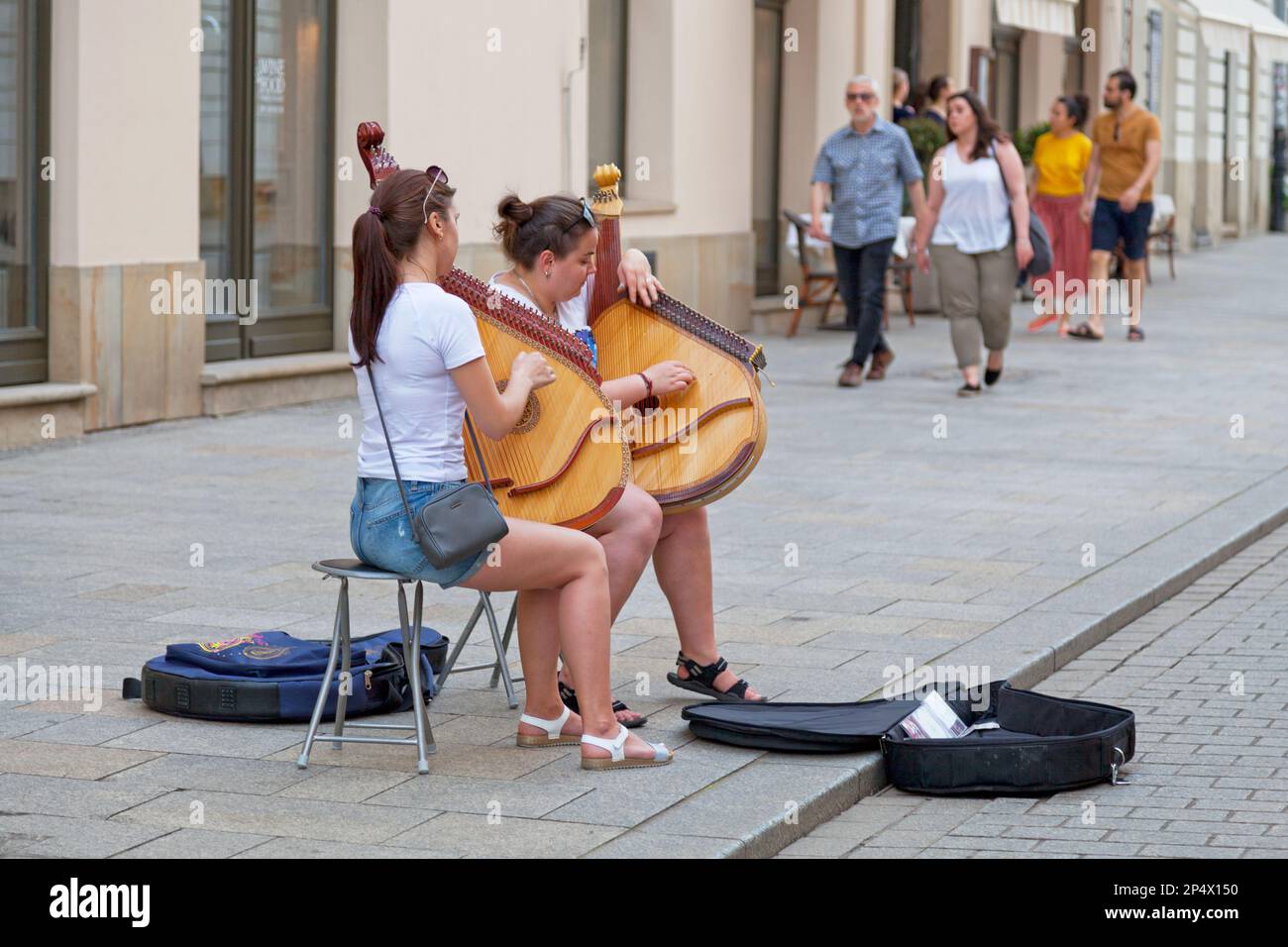 Krakow, Poland - June 06 2019: Two young women playing banduras in a touristic street. A bandura (Ukrainian: банду́ра) is a Ukrainian, plucked string, Stock Photo