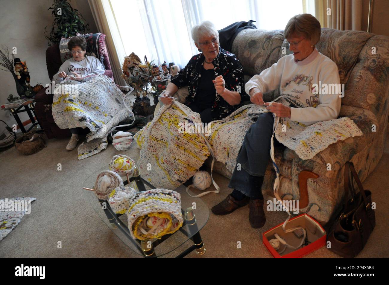 From left, Madeline Schmoldt, Carlyn Koenig and Carline Mencl crochet bed  pads from plastic bags. The group meets monthly and donates the final  product to people in need. (AP Photo/Beatrice Daily Sun,