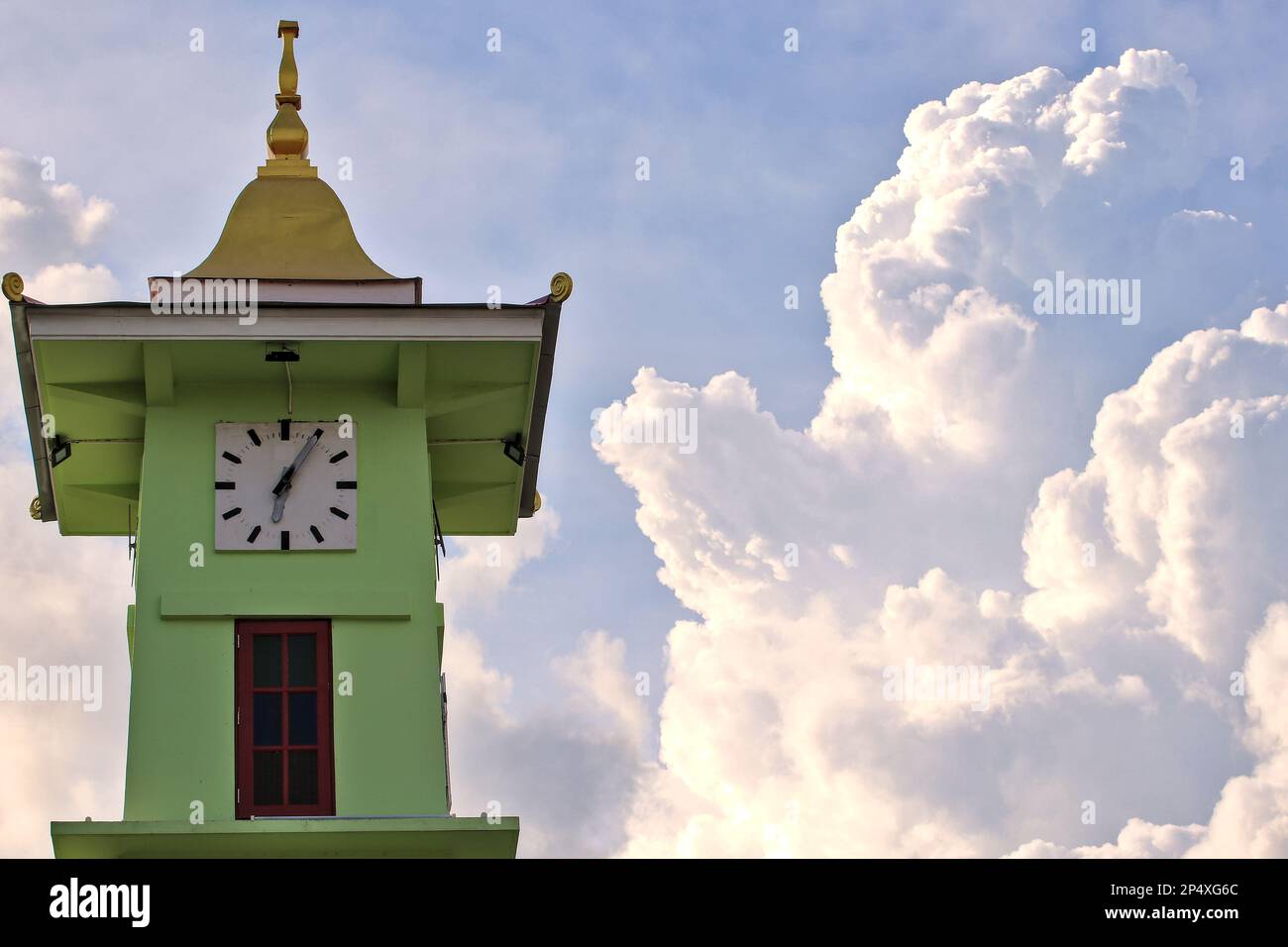 clock tower and big cloud The concept of material time and natural time. Stock Photo