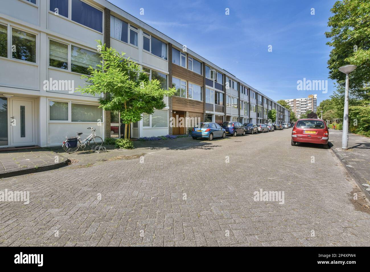 a city street with cars parked on the side and buildings in the back ...