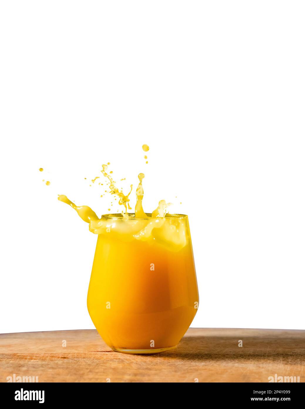 Glass of fresh orange juice splash on on wooden table and white