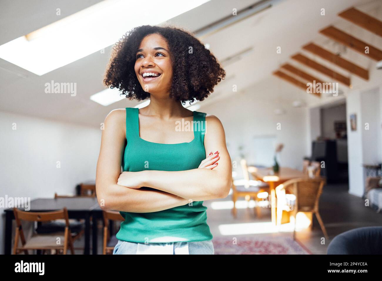 Happy african american woman stands in her living room and smiles ...