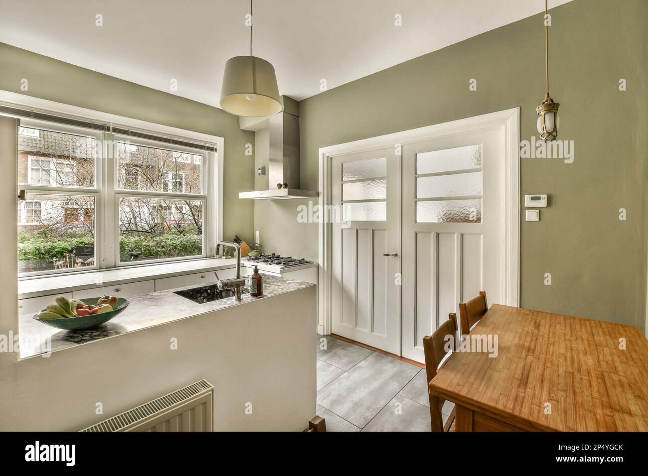a kitchen and dining area in a house with green walls, white trim