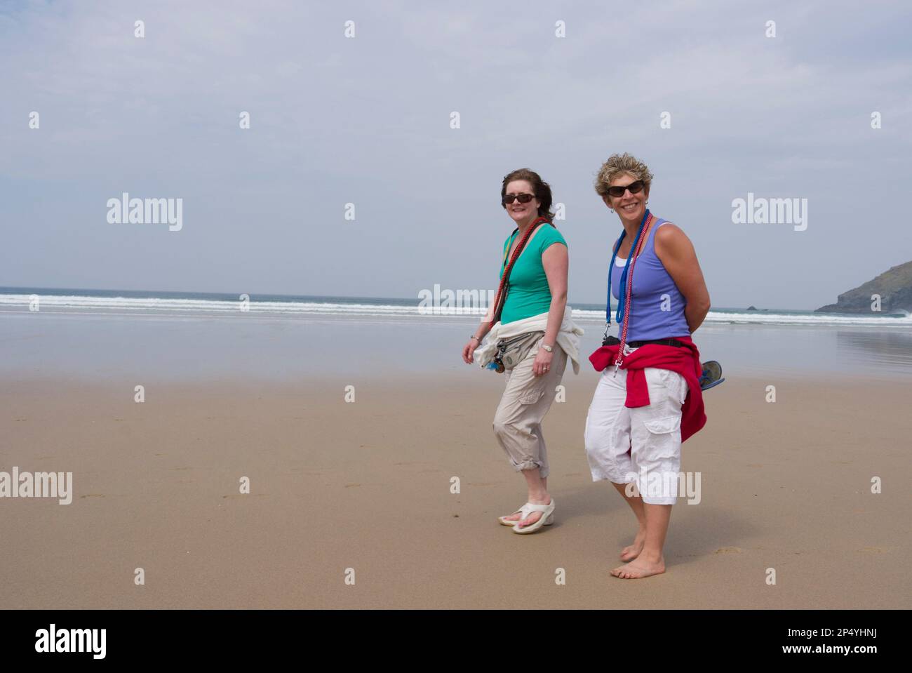 Two women walking on a sandy beach Stock Photo