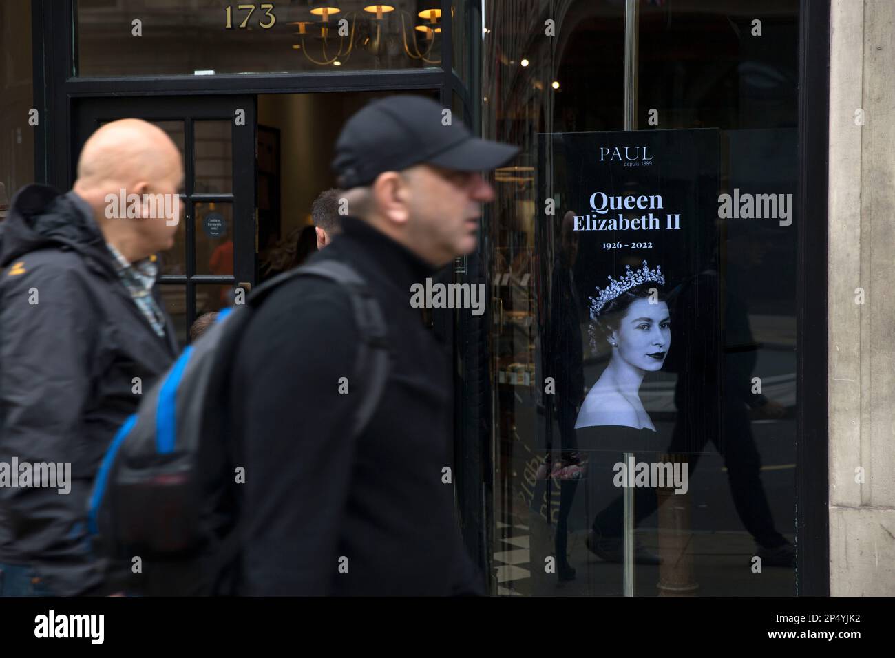 A portrait of the late Queen Elizabeth II is seen as mourners gather to pay their respects in central London, on the day of her funeral. Stock Photo