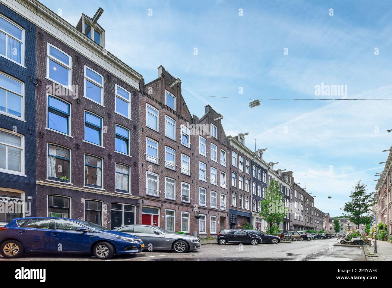 a city street with cars parked on the side and buildings in the back ...