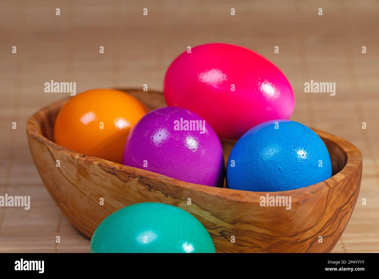 Colorful chicken eggs in a wooden bowl Stock Photo