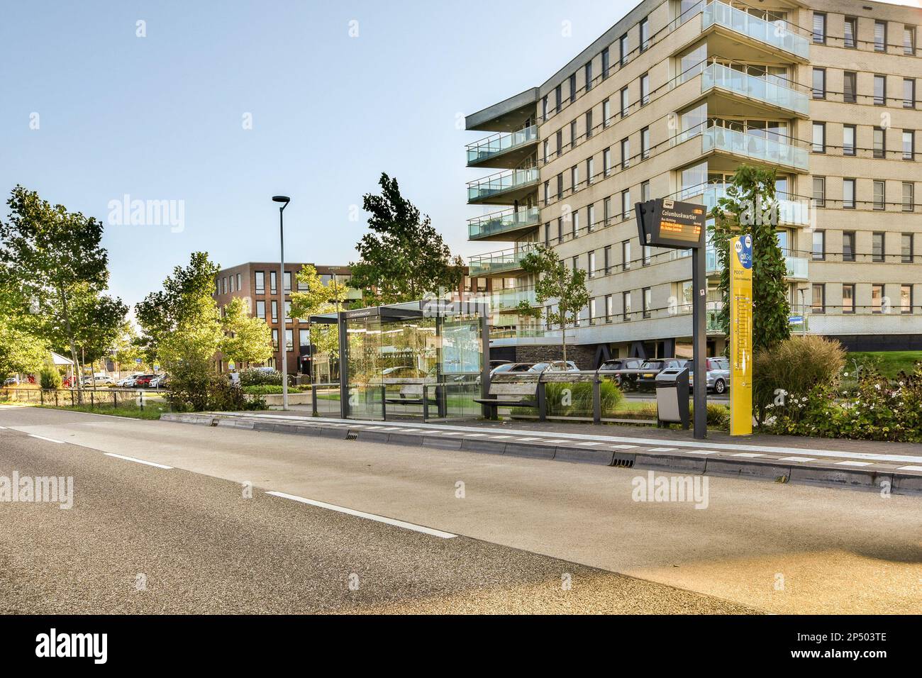 a city street with cars parked on the side of the road and buildings in ...
