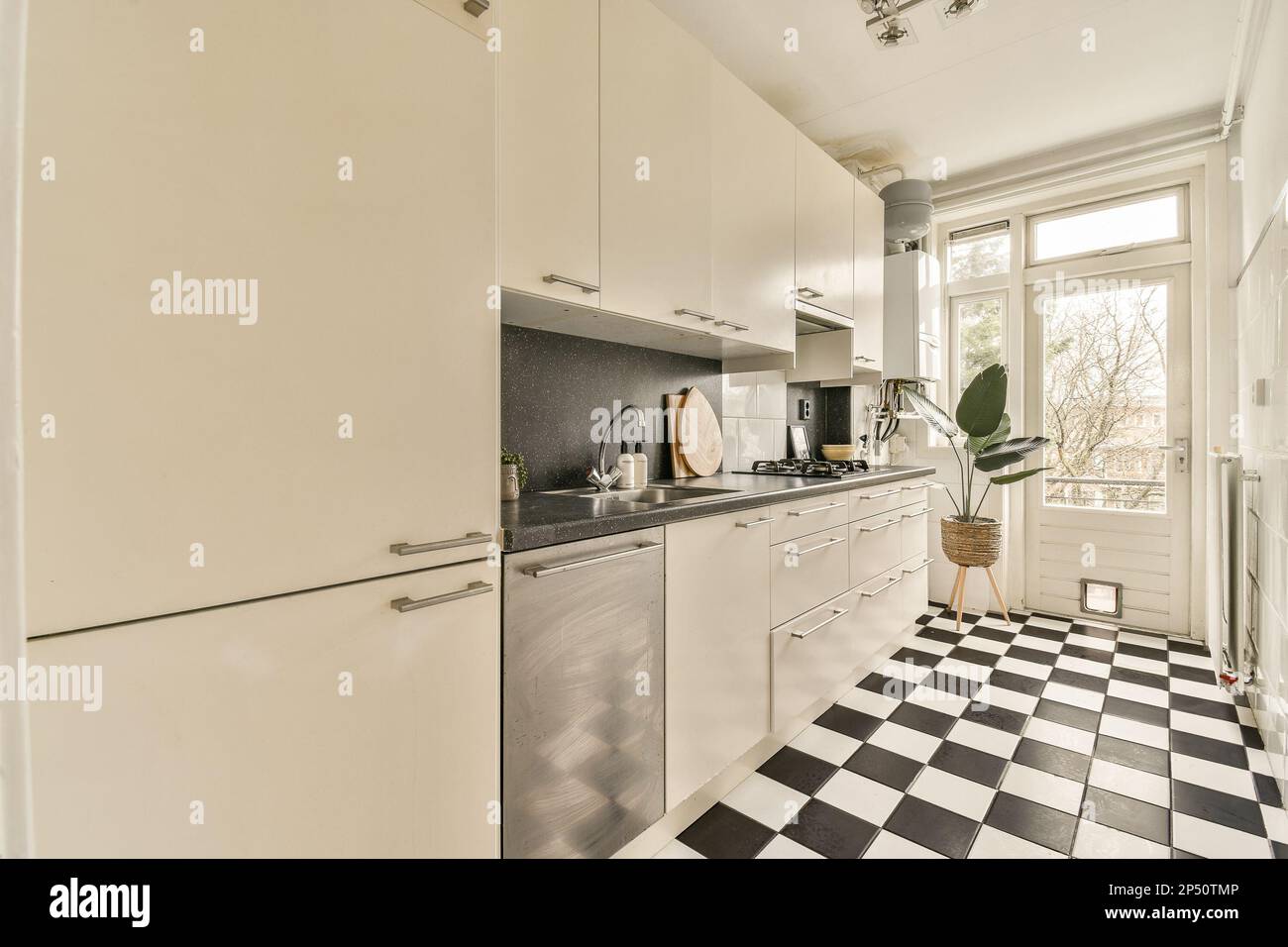 a kitchen with black and white checkered tiles on the floor in front of