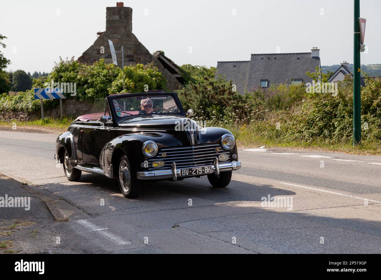 Kerlaz, France - July 17 2022: Retired man cruising in a black Peugeot 203 convertible. Stock Photo