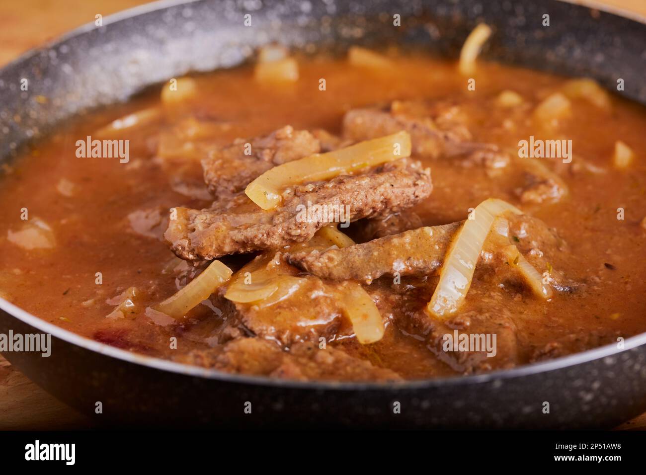 Liver and onions in gravy resting in a pan. Stock Photo