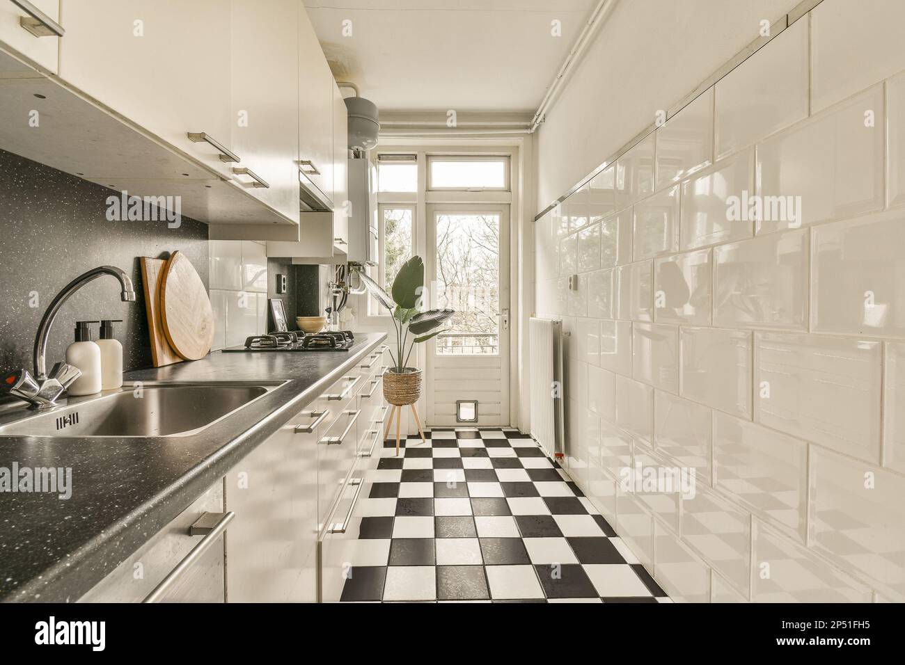 a kitchen with black and white checkered tiles on the floor, along with