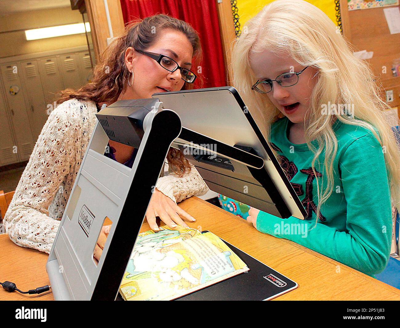 https://c8.alamy.com/comp/2P51J83/advance-for-monday-oct-28-in-an-oct-15-2013-photo-lisa-pelc-hillsdale-isd-visually-impaired-teacher-consultant-works-with-gier-elementary-first-grader-alexis-nichols-as-she-reads-with-a-visiobook-at-the-school-in-hillsdale-mich-the-device-magnifies-the-text-of-the-book-helping-nichols-read-as-a-baby-nichols-was-diagnosed-with-albinism-which-has-caused-vision-problems-for-her-her-vision-problems-arent-curable-with-glasses-or-surgery-ap-photohillsdale-daily-news-andy-barrand-2P51J83.jpg