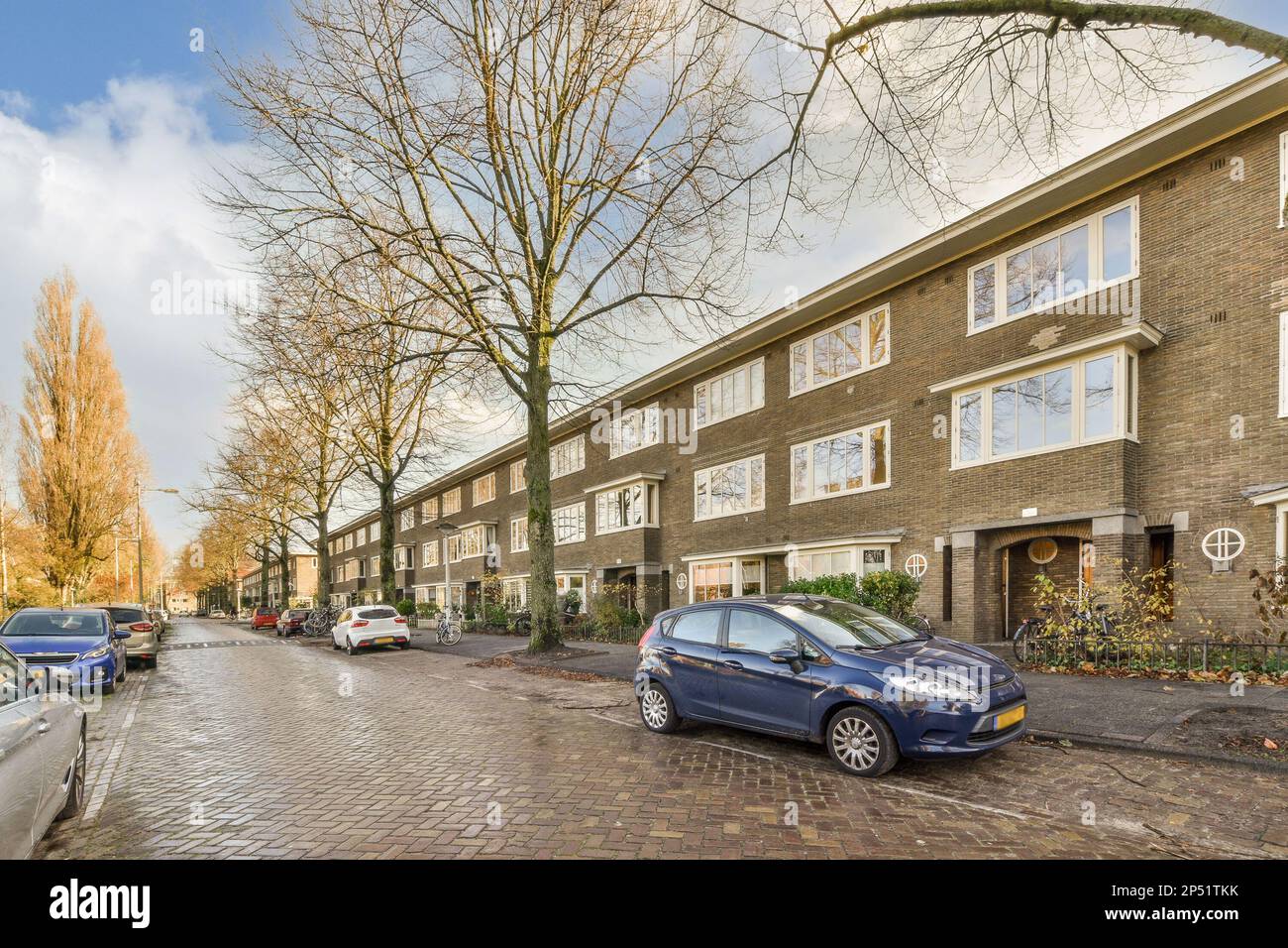 a street with cars parked on the side and buildings in the back ground ...