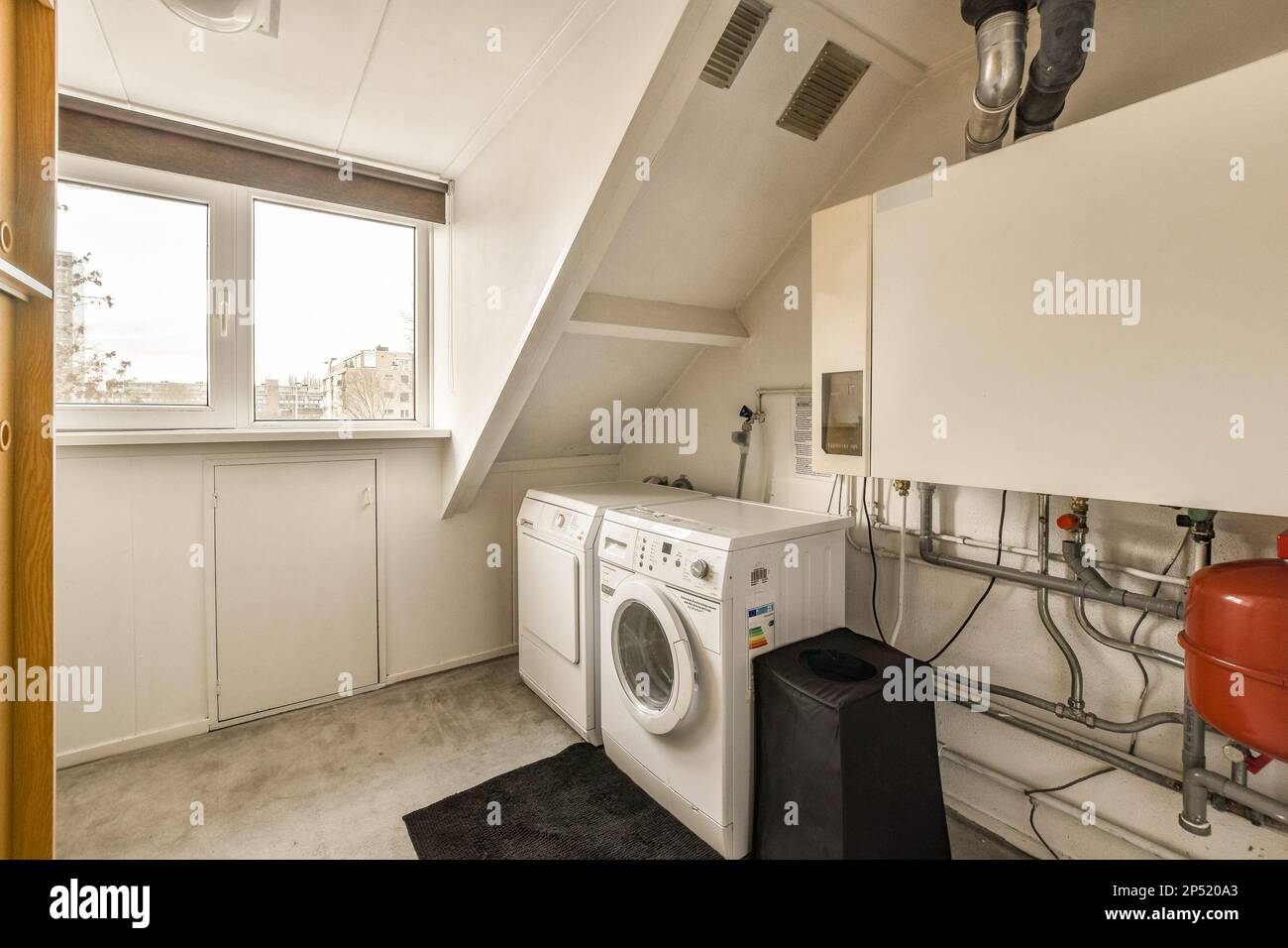 a laundry room with a washer, dryer and washing machine in the corner next  to an open window Stock Photo - Alamy