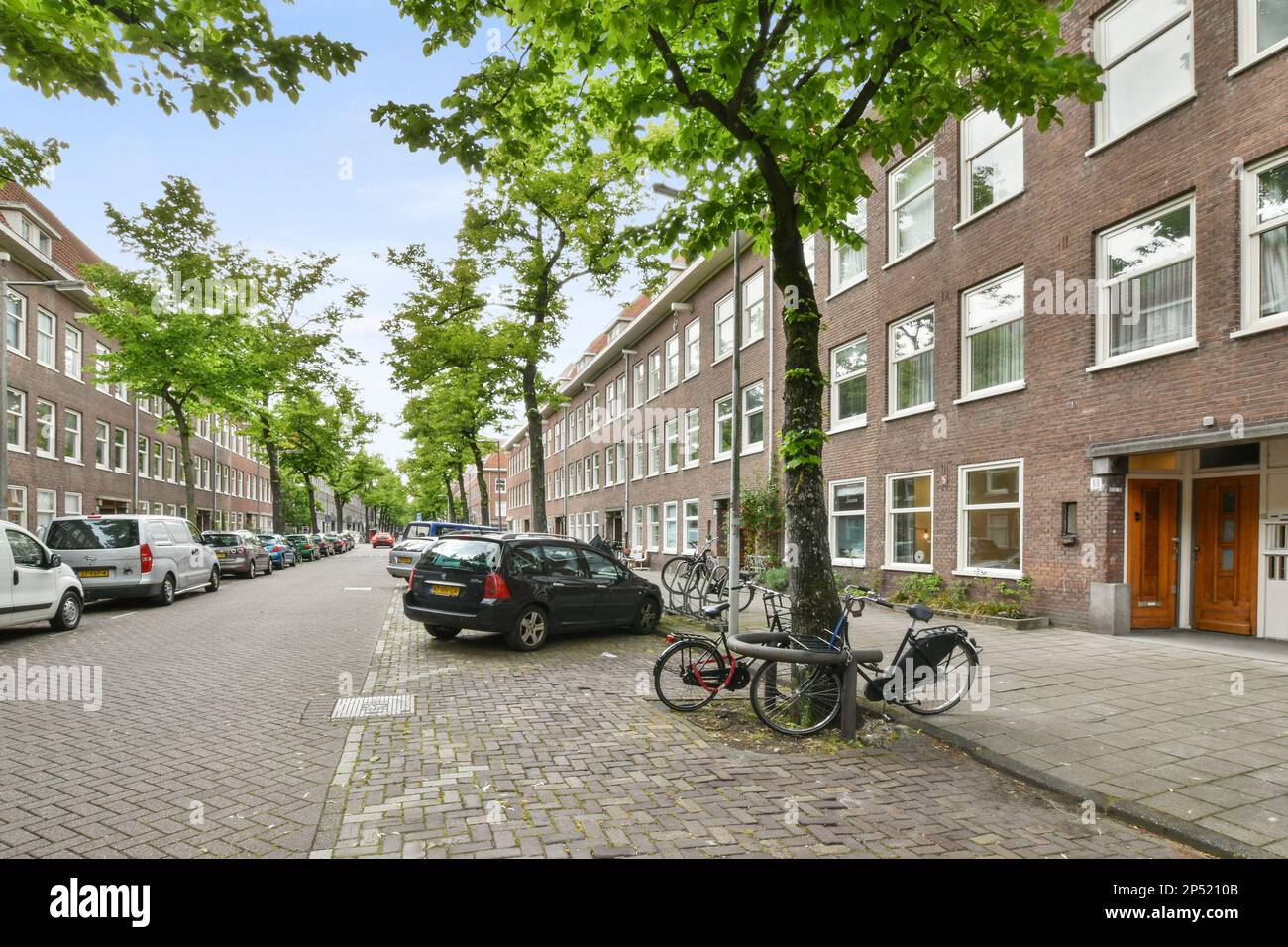 a street with cars parked on the side and buildings in the back ground ...