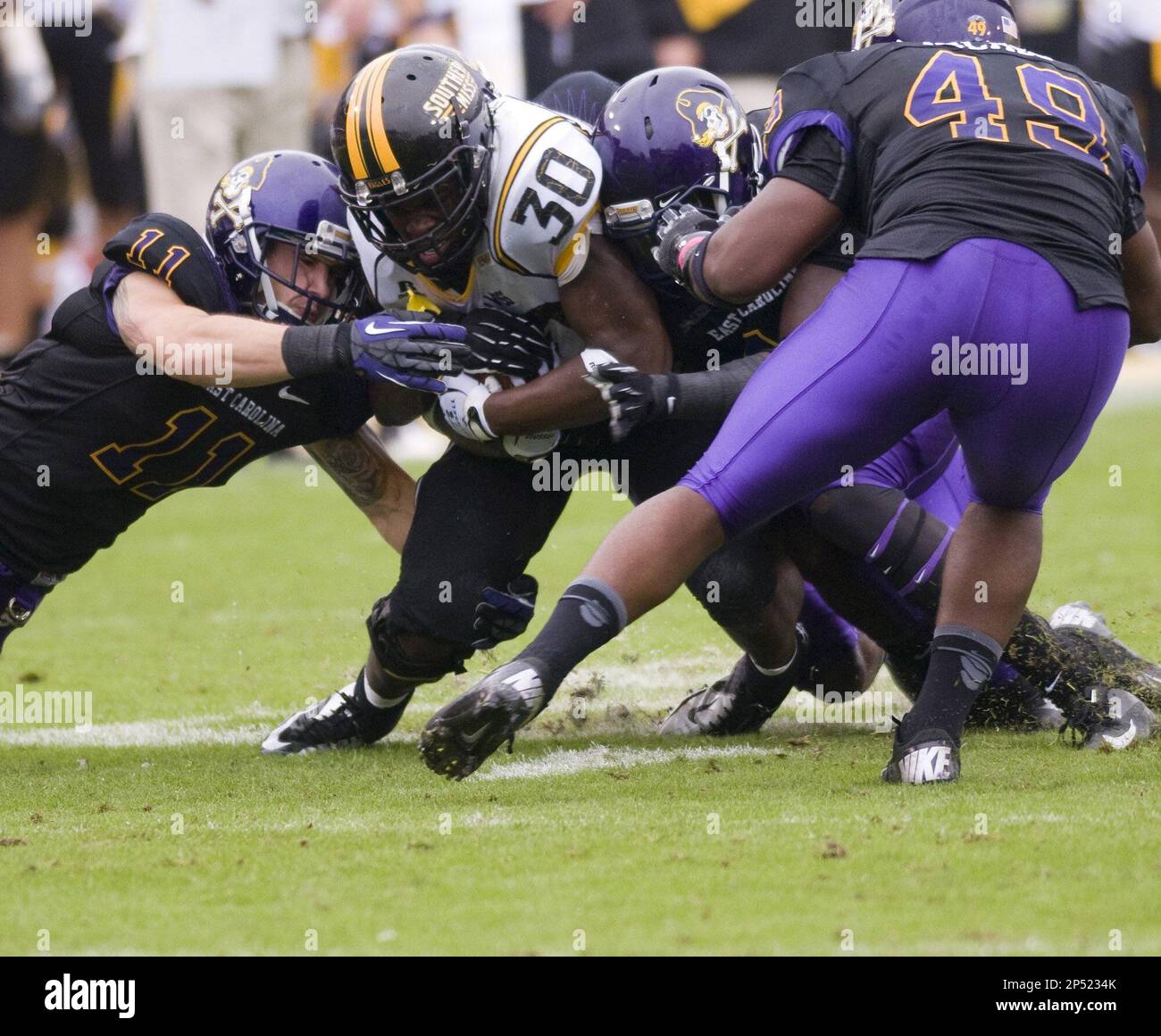 Southern Miss's Jalen Richard is brought down by East Carolina's Damon  Magazu (11), Adonis Armstrong (3) and Ty Holmes (49) second half of an NCAA  college football game at Dowdy-Ficklen Stadium Saturday,