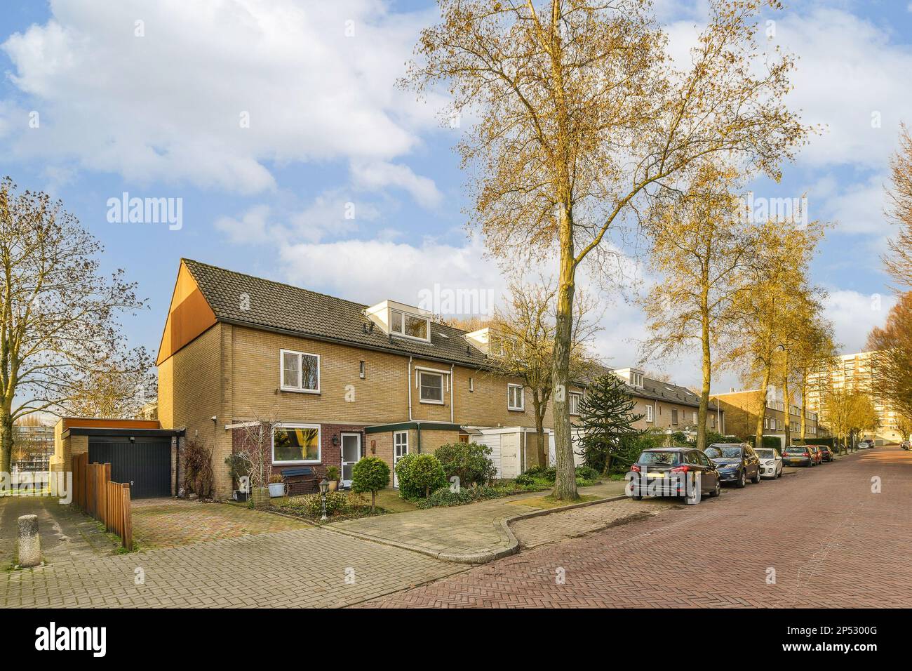 a street with cars parked on the side and houses in the back ground ...