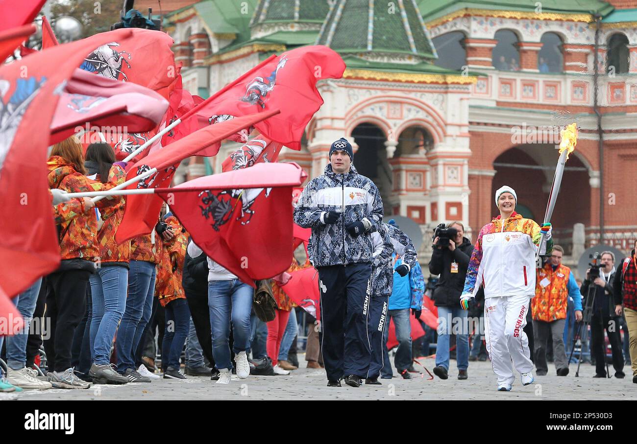 A first torchbearer Anastasia Davydova, synchronized swimmer, attends  Russian Olympic torch relay at Moscow's Red Square on Oct. 7, 2013. The  official 123-day torch relay kicked off and torchbearers will run  65,000-kilometer
