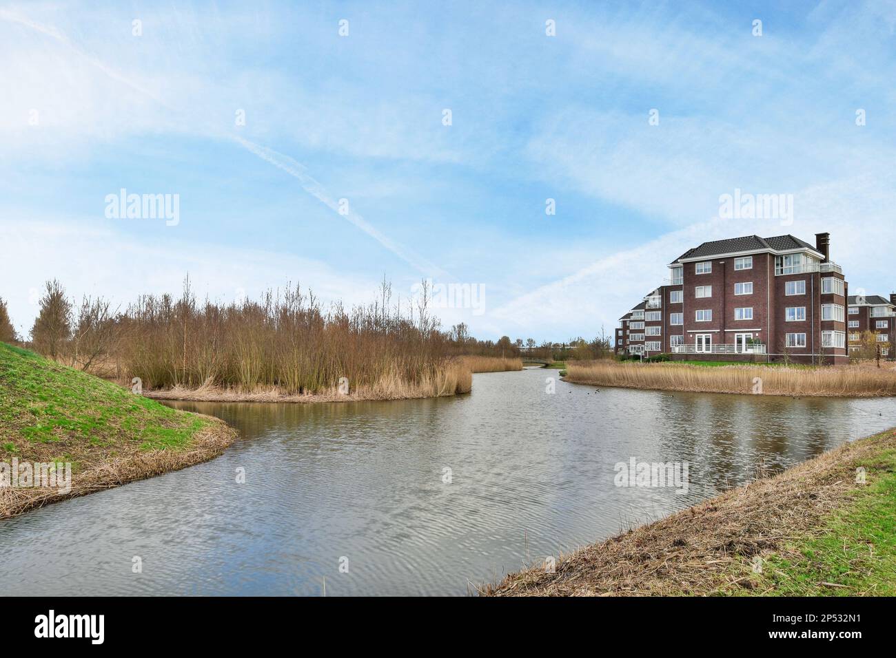 a river in the middle of a residential area with houses on either side ...