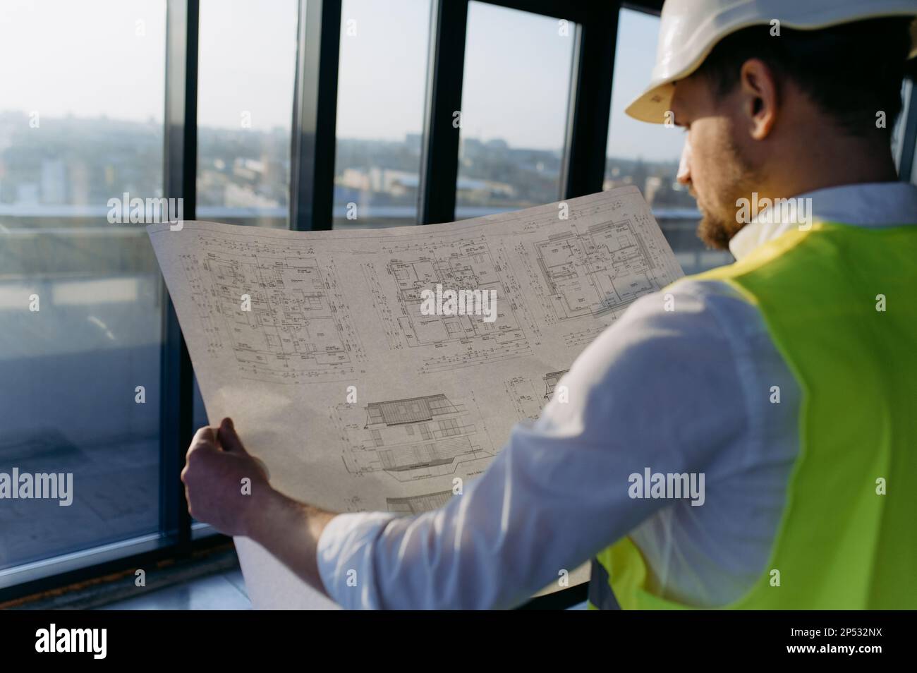 male engineer working on an architectural project at a construction site in the office. Stock Photo