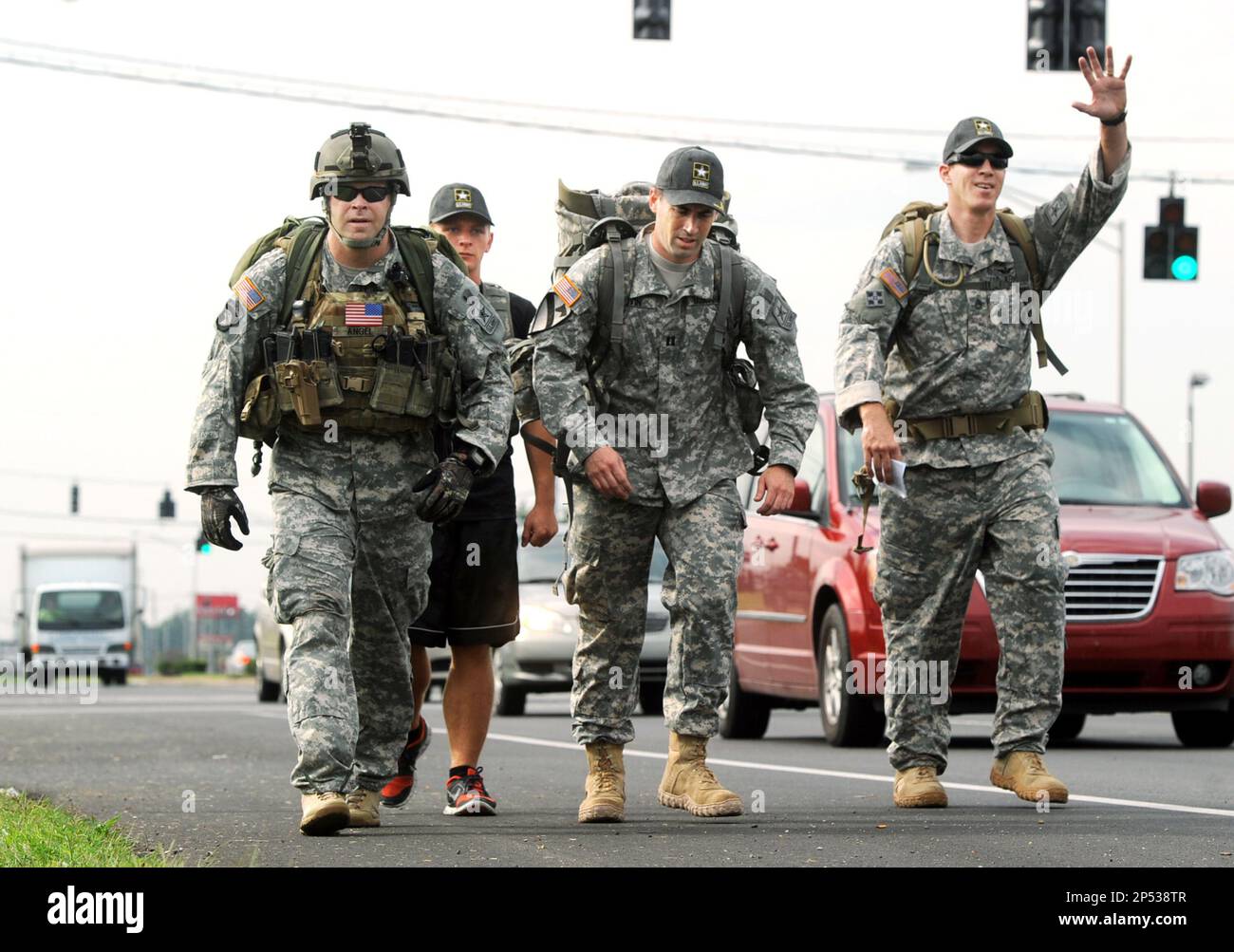 United States Army Sgt. 1st Class, Scott Beech, right, waves to a 
